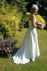 Woman walks with flowers in a wedding dress.